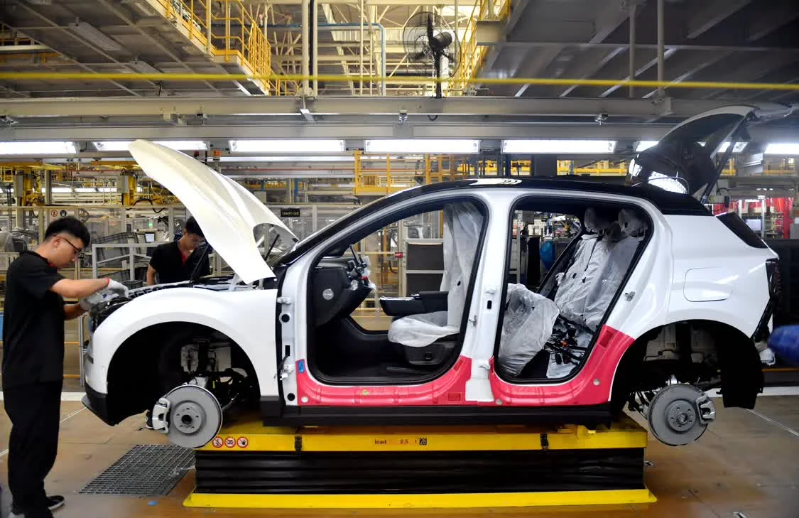 6月19日，工作人员在张家口南山汽车产业基地一家车企的总装车间组装汽车。新华社记者 王晓 摄