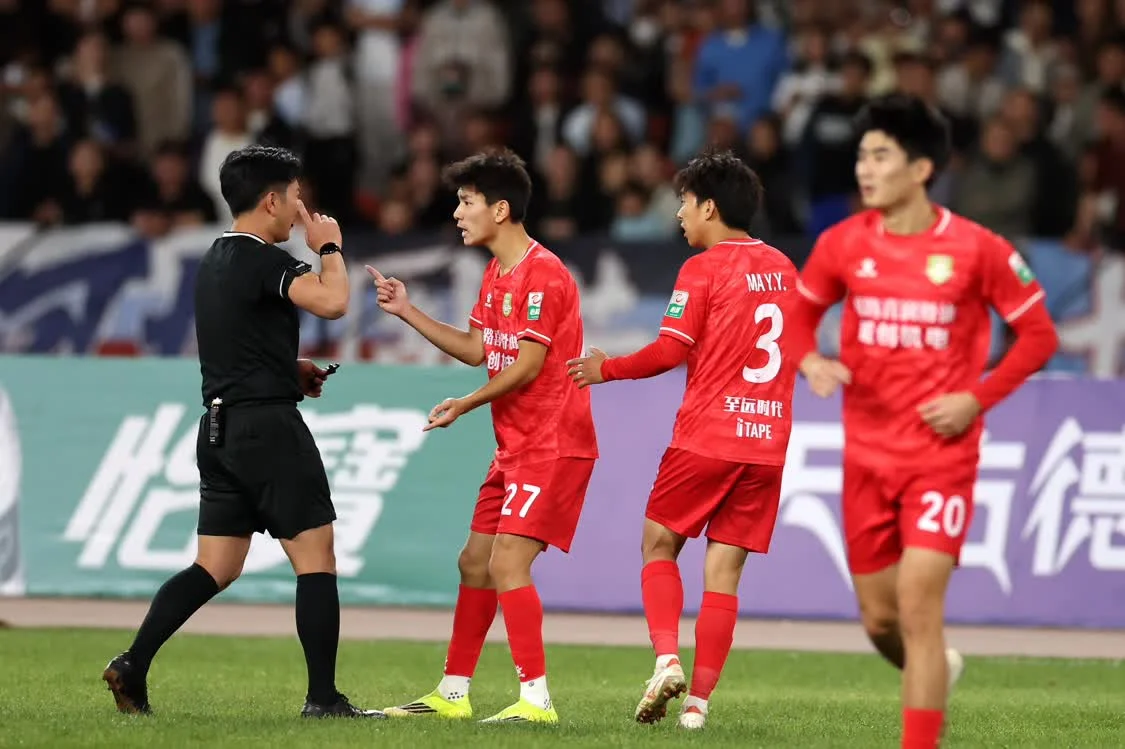 4月5日，长春喜都队球员徐浩峻萌（左二）在比赛中与主裁判袁仕伟沟通。新华社记者　陈斌　摄