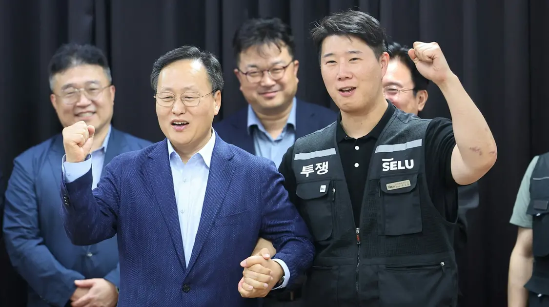 5月20日,韩国三星电子超企业工会主席崔承浩(右)与三星设备解决方案事业部人事部负责人兼公司首席管理谈判代表吕明九(左)在达成初步薪酬协议后合影留念。路透社