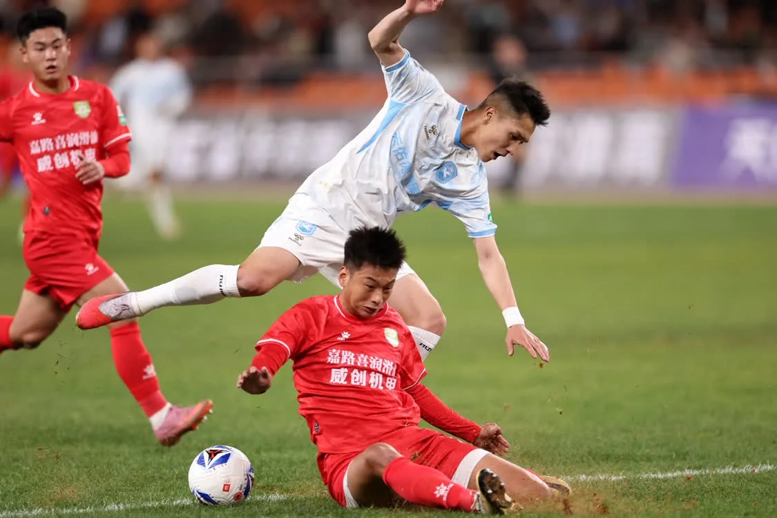 4月5日，兰州陇原竞技天佑德队球员乌拉尔&middot;木合塔尔（上）与长春喜都队球员耿祥龙（下）在比赛中拼抢。新华社记者　陈斌　摄
