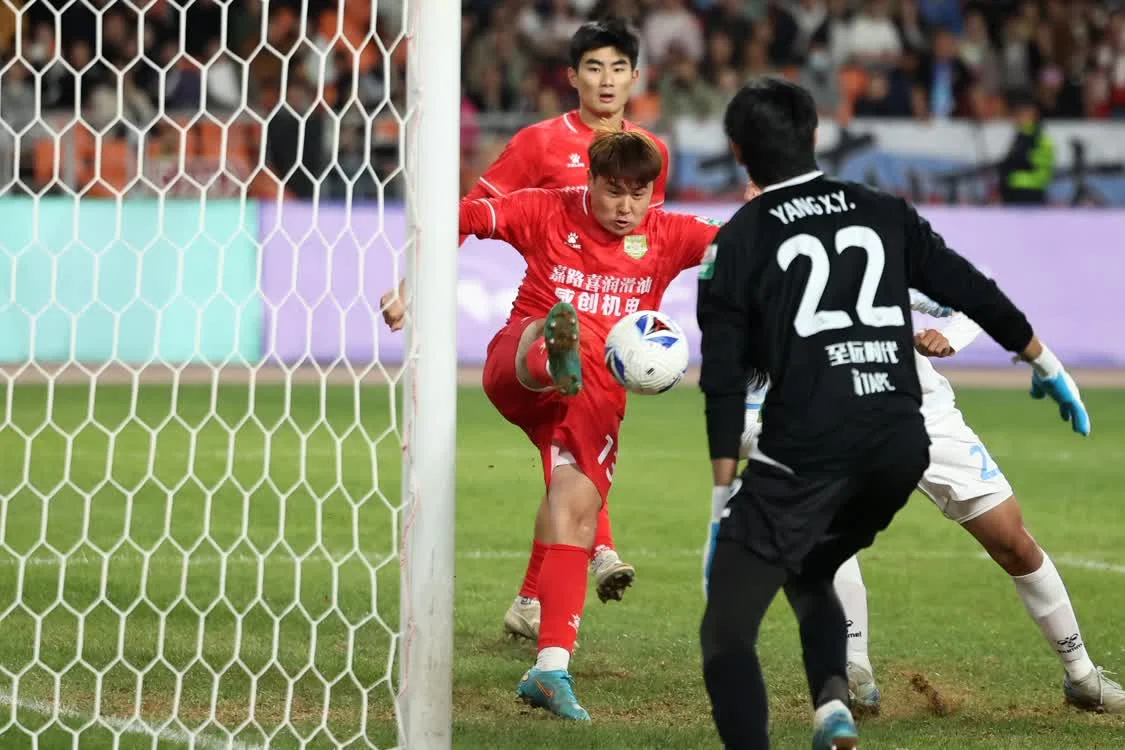 4月5日，长春喜都队球员王天赐（左）在比赛中门前解围。新华社记者　陈斌　摄