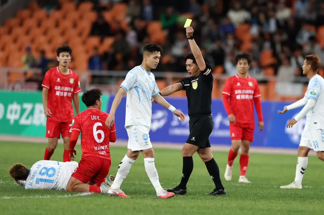 4月5日，主裁判袁仕伟向长春喜都队球员刘洋（左三）出示黄牌。新华社记者　陈斌　摄
