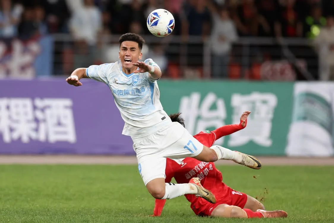 4月5日，兰州陇原竞技天佑德队球员阿巴别克热&middot;艾尔肯（左）在进攻中被对手犯规倒地。新华社记者　陈斌　摄