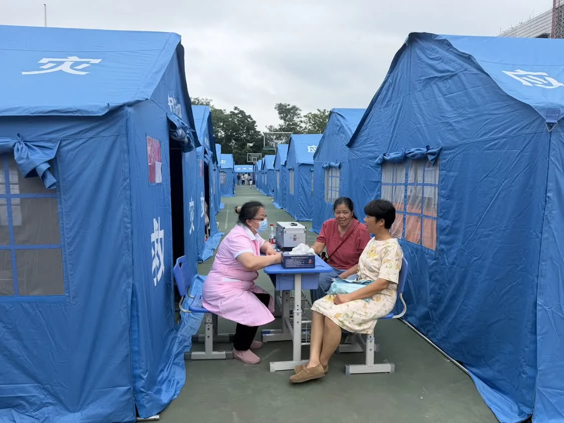 在太阳村中心校安置点，医护人员与居民沟通健康情况。新华社记者 农冠斌 摄