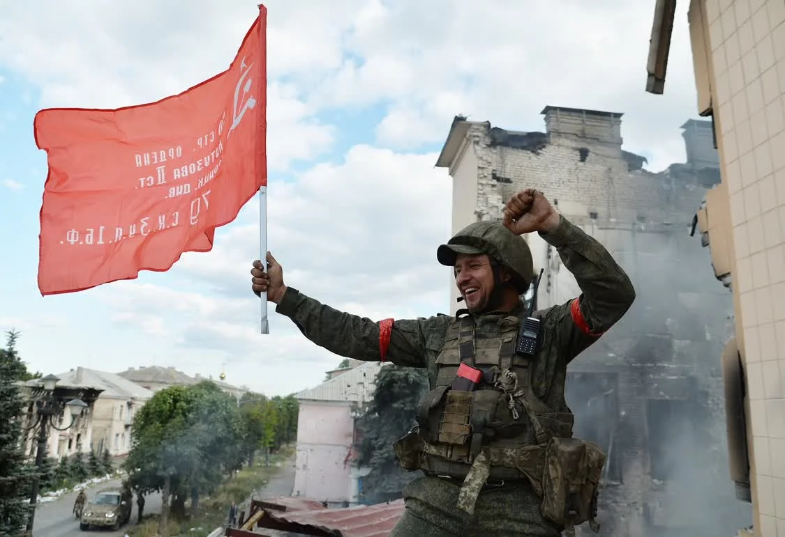 当地时间2022年7月2日，卢甘斯克地区，利西昌斯克市行政大楼上，卢甘斯克武装第6哥萨克团的一名战士在悬挂前苏联的旗帜。