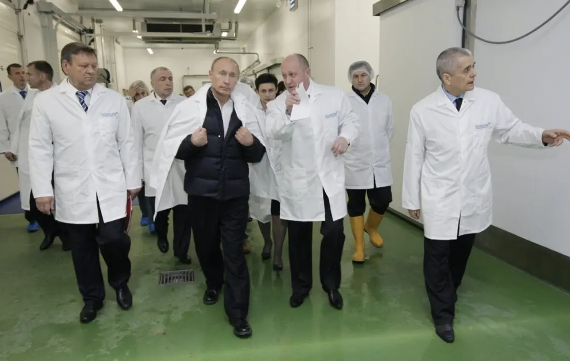 俄罗斯官媒2010年发布的照片显示，叶夫根尼·普里戈任（中右）与普京在圣彼得堡郊外为学校制作午餐的工厂。