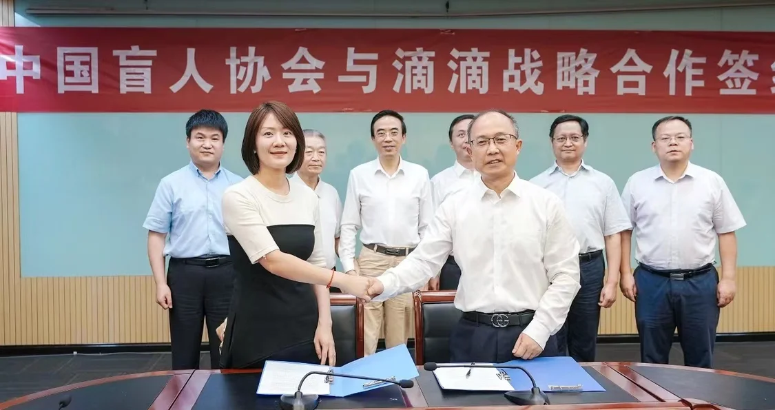 中国盲协主席李庆忠（右）与滴滴企业社会责任总监罗真真（左）签署战略升级合作协议。