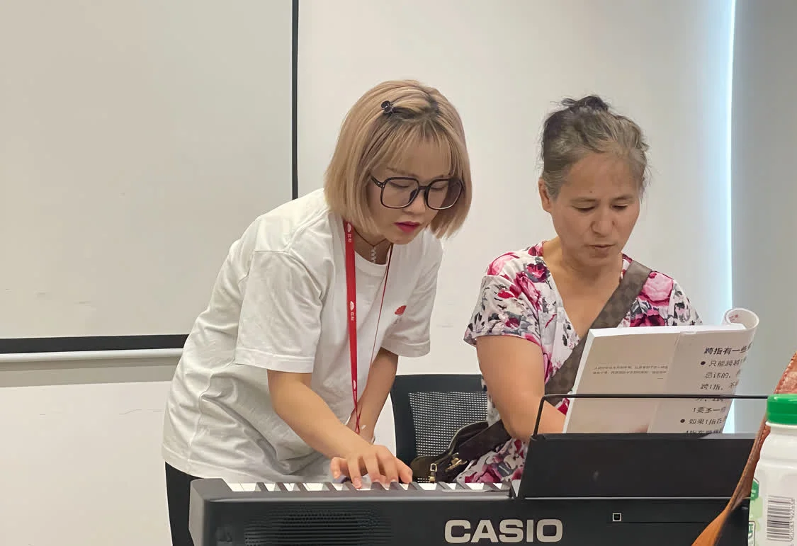 图：周茂指导红松学员练习电子琴