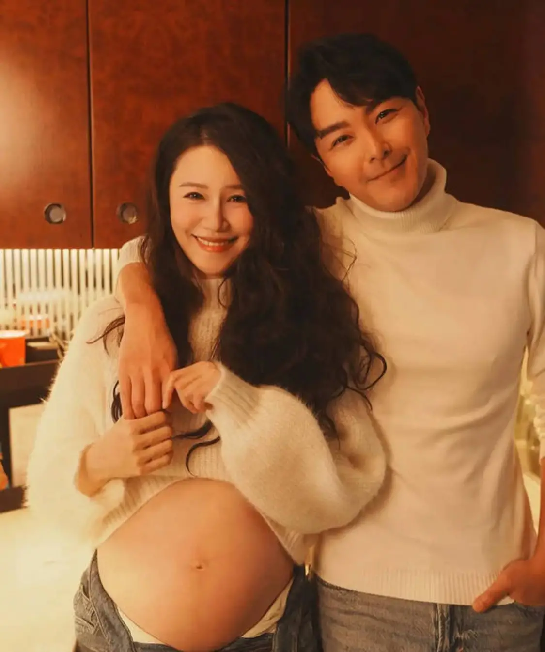 两人对着镜头笑得温柔，画面温馨。