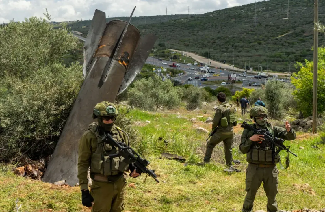 2026年3月24日，以色列士兵站在約旦河西岸巴勒斯坦村莊哈雷斯的一枚嵌入地面的伊朗飛彈附近。