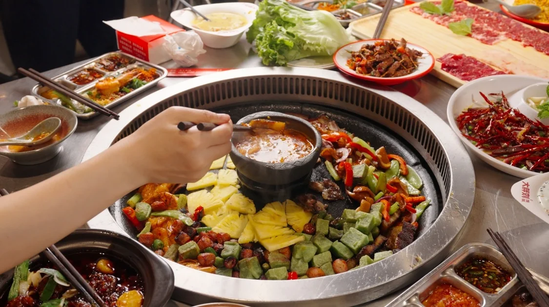 图|洋芋、豆腐和蔬菜围着蘸水铺开,一锅烙锅也把一桌人围到了一起。