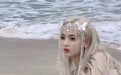 杨超越自创“海的女儿”造型 白金色头发加蝴蝶发饰斜躺沙滩