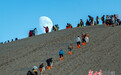 游客观赏月上敦煌鸣沙山