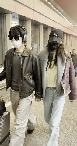 两人穿同款皮衣快步前行。