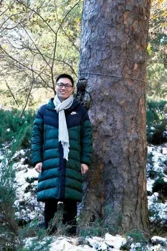 在中国松古树踏查中，钮世辉与一株300多年的古树合影