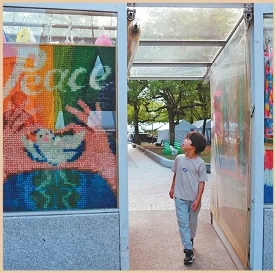 在日本广岛和平纪念公园，一名小朋友经过祈愿和平的千纸鹤叠串。新华社记者 贾浩成摄