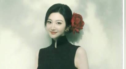 景甜黑色无袖旗袍裙撕拉片，头戴大红花演绎复古明艳风