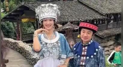 王祖蓝与李亚男在乌江，身穿苗族服装拍摄，王祖蓝一脸无奈的感觉
