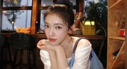 林允斜肩白衣搭配丸子头 明媚笑容可盐可甜