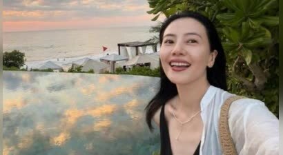 高圆圆身着深棕吊带裙海边度假 46岁素颜状态出众