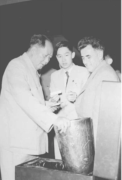 毛泽东接见南共代表团团长维塞林诺夫并观看南共向毛泽东赠送的民间工艺品：一支由南斯拉夫手工艺人制作的雕花银瓶。这是阎明复第一次给毛泽东做翻译