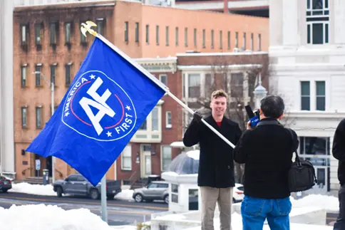 ▎特朗普支持者高举“让美国再次优先”的旗帜 图源：Shutterstock