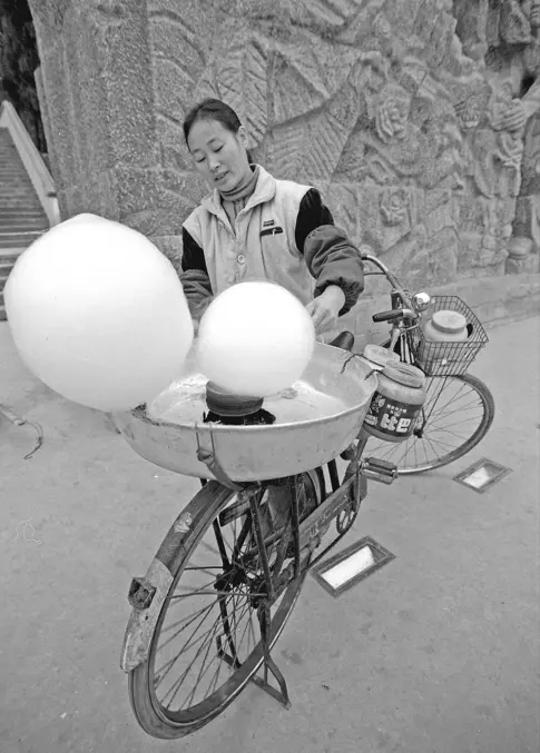 推着单车的卖糖人，车尾架上，是台神奇的绕棉花糖机，2006年贵州遵义
