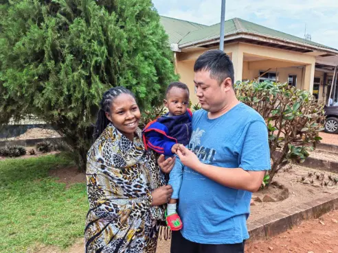 （图为中交二公局国际公司坦桑尼亚BK二标工程部部长张林，和被救婴儿及其母亲。受访者供图。）