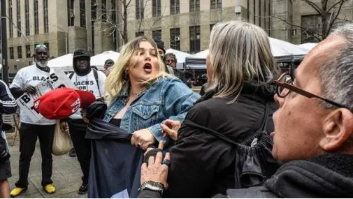 当地时间4月4日，美国前总统特朗普的支持者（中）和抗议者在纽约刑事法庭外发生冲突。图源：外媒