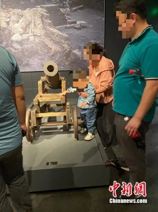 图为徐州博物馆内，有家长抱着孩子触摸馆内藏品。 马壮 摄