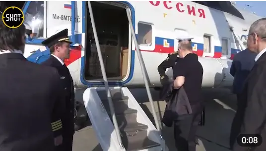 普京在直升机登机口前与拎黑色手提箱的军官握手，还帮忙整理了下他的军装 图自“SHOT”账号画面截图