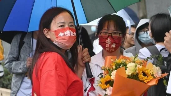 6月8日，全国部分地区2022年高考结束。图为家长戴“金榜题名”口罩在昆明市北清实验学校考点外迎接考生。中新社记者 李嘉娴摄