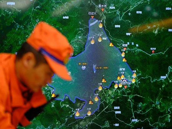 8月19日，四川省广安市，四川省森林消防总队一线指挥员研判火场态势，他身后的屏幕上显示着林内的火点信息。程雪力/摄