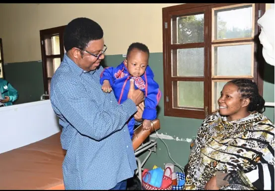 （图为坦桑尼亚总理马贾利瓦探望被张林救起的婴儿及其母亲。受访者供图。）