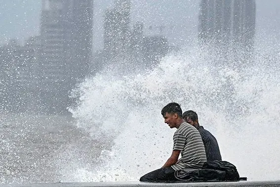 2023年7月6日,一些年轻人在印度孟买的海边戏浪纳凉