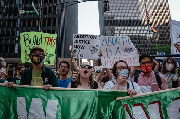 堪萨斯州利伍德的反堕胎抗议者（上），与此同时，另一些支持堕胎的民众在芝加哥举行游行（下）（《纽约时报》图）