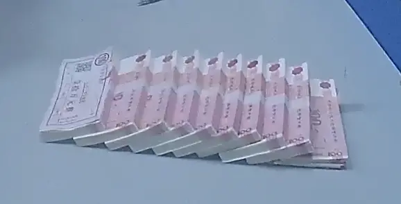 ↑李某给陶女士的10万现金为网上购买的“点钞练功券”。