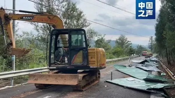 挖掘机正在对九龙瀑布景区沿线遮挡视线的围挡进行拆除（罗平县委宣传部供图）