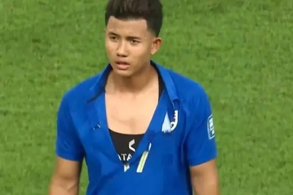 拼抢中，泰国队球员的球衣被撕破。