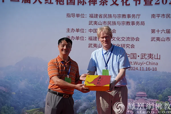 组委会代表郑坚敏向何心鹏教授赠送“祖庭大红袍茶礼”