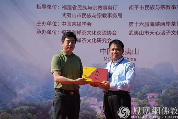 组委会代表梁晓东向高明赠送“祖庭大红袍茶礼”