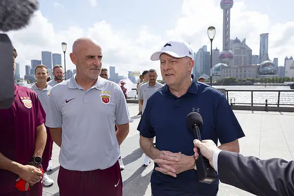 7月13日，上海，阿尔巴尼斯与前澳大利亚国脚、上海海港足球俱乐部主教练凯文·马斯凯特一同在外滩散步。 视觉中国