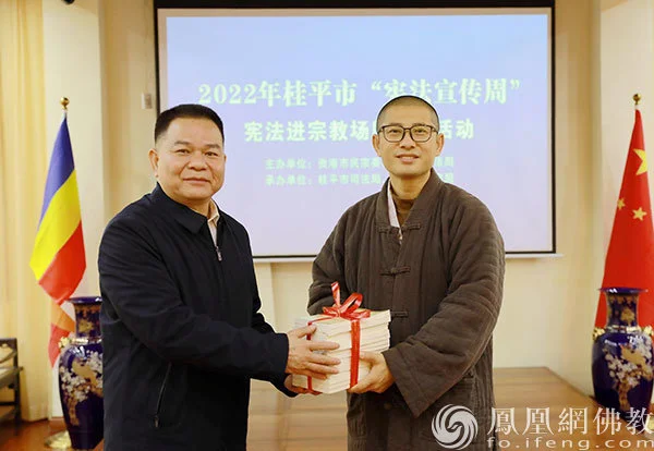 贵港市司法局党组成员、副局长黄志军为龙华古寺赠送《中华人民共和国宪法》《中华人民共和国民法典》（图片来源：凤凰网佛教 摄影：张满常）