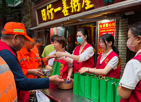 志愿者在日行一善粥屋给老人们、环卫工人送去节日祝福