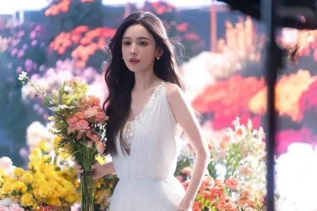 搜狐娱乐讯 12日，古力娜扎最新花絮美照曝光，她身穿白色长裙化身春日捧花少女，气质清纯动人，十分养眼！