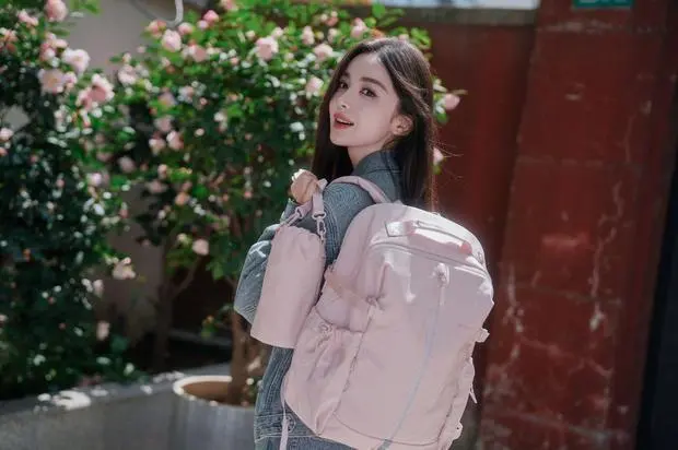 娜扎拎包侧身，花前拍摄清新灵动。