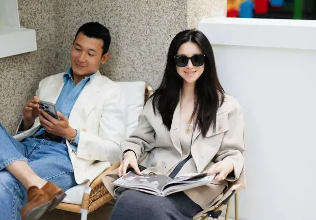 朱珠翻书浅笑，整体氛围慵懒惬意。