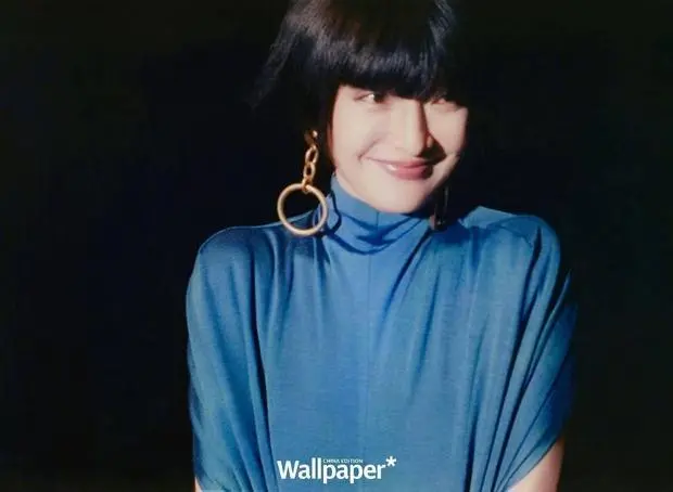 周迅浅笑垂眸，金环耳饰显复古韵味。