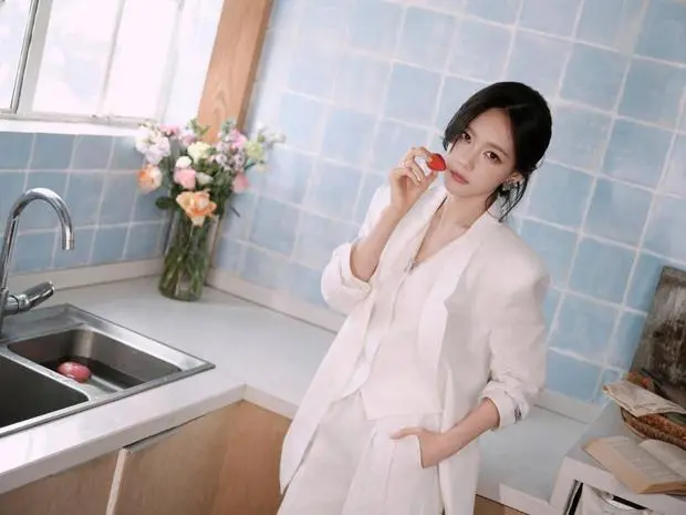 李一桐拈草莓近脸，眼神灵动娇俏。