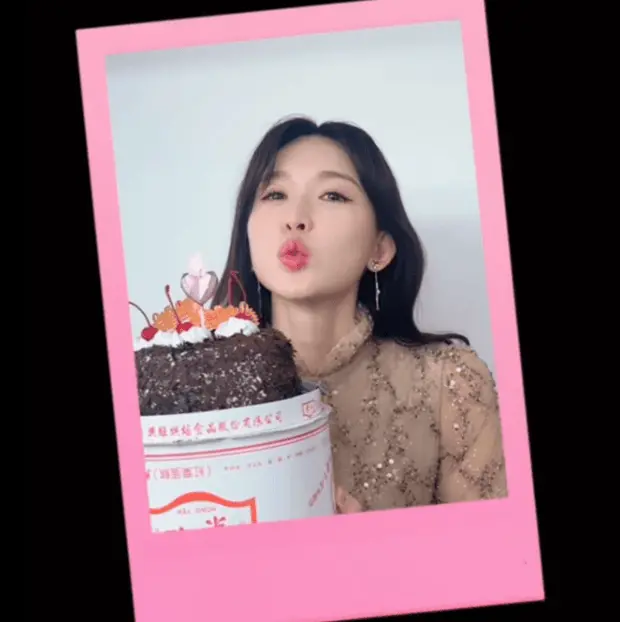 林志玲手捧蛋糕做出可爱表情。